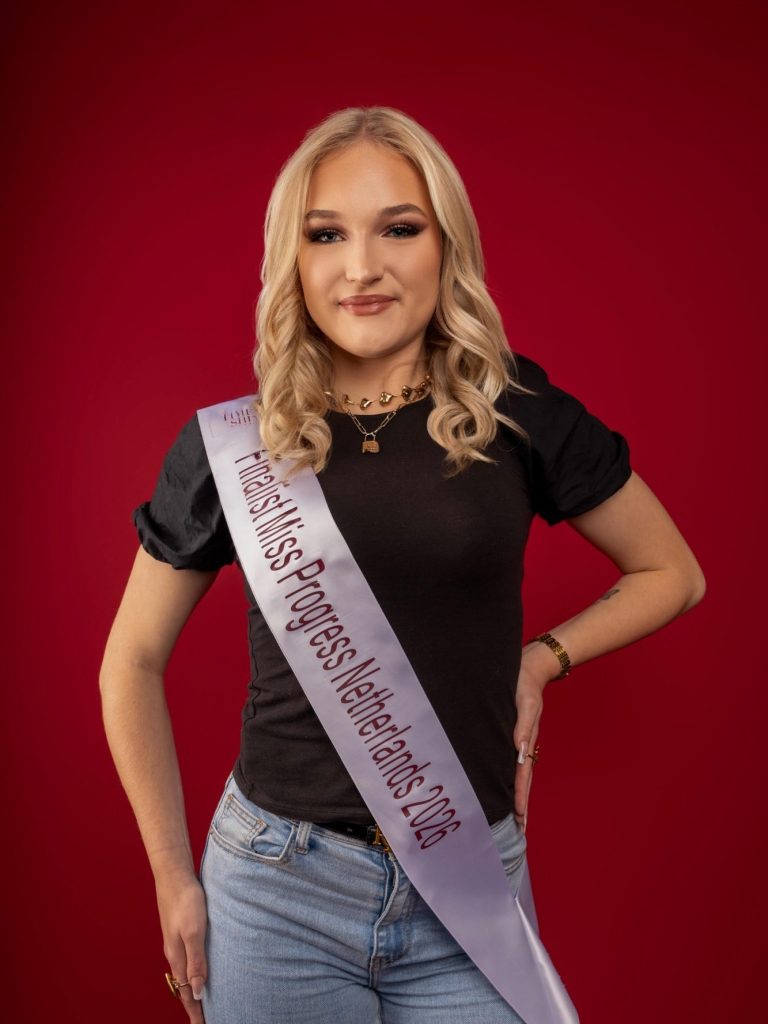 We zien Maud, een jonge vrouw met blond haar, zwarte top en Missen sjerp op een rode achtergrond.